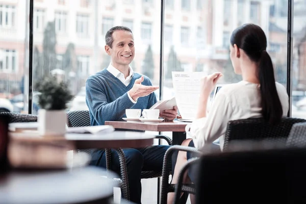 Positive delighted man talking to his colleague