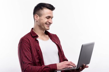 Gülümseyen genç adam onun laptop kullanma