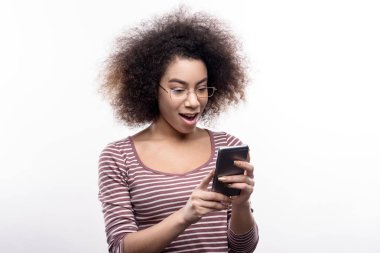 Kıvırcık saçlı kadın telefon haber okurken şaşkınlık