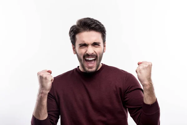 Overjoyed young man raising hands in triumph — Stock Photo, Image