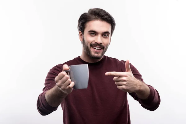 Joven alegre señalando la taza de café — Foto de Stock