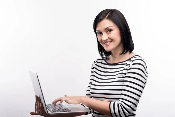 Charmante Frau posiert während der Arbeit am Laptop — Stockfoto