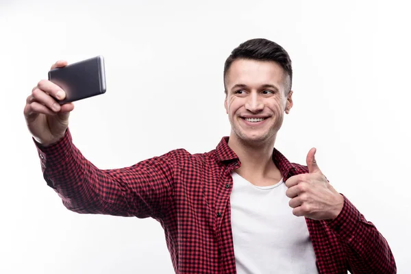 Homem otimista tomando selfies e mostrando polegares para cima — Fotografia de Stock