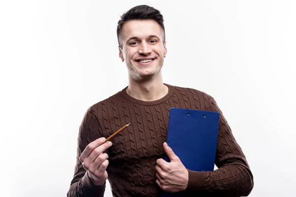 Charming man holding sheet holder and pencil — Stock Photo, Image