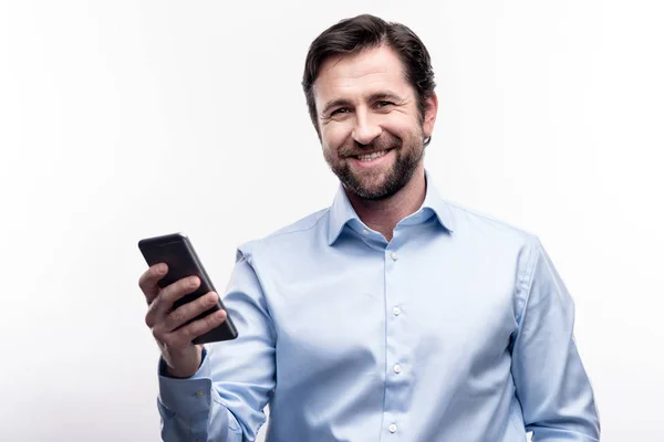 Hombre barbudo de mediana edad posando con su teléfono celular — Foto de Stock