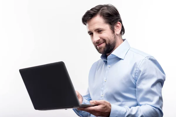 Angenehmer Geschäftsmann mittleren Alters, der an seinem Laptop arbeitet — Stockfoto