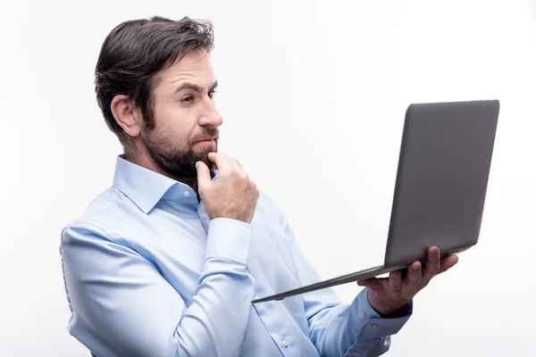 Hombre de negocios guapo leyendo informe sobre el ordenador portátil —  Fotos de Stock