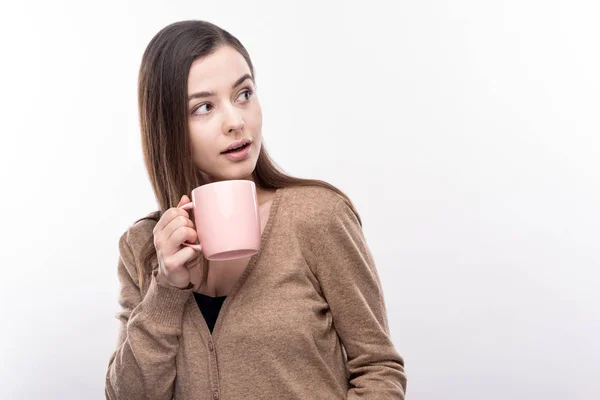 Mooie vrouw wordt afgeleid door de geluiden terwijl het drinken van koffie — Stockfoto