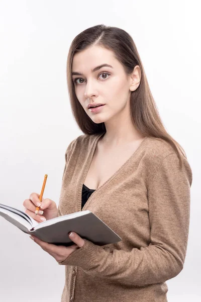 Trevlig ung kvinna skriver i anteckningsbok — Stockfoto