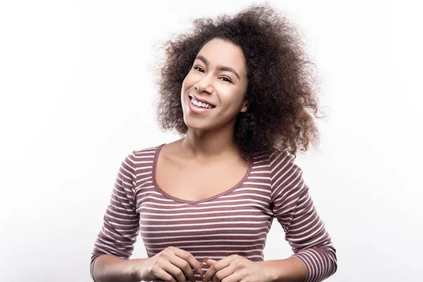 Curly-haired woman smiling endearingly at camera — Stock Photo, Image