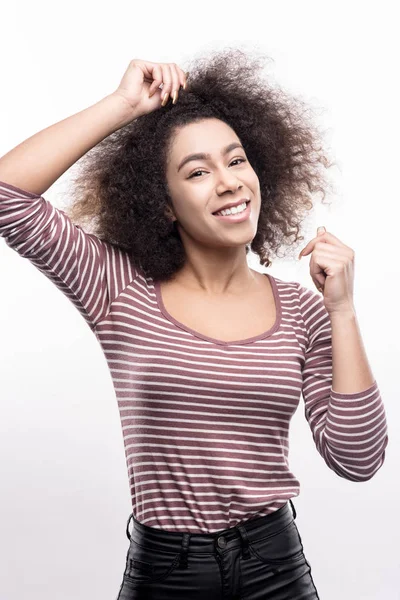 Beautiful woman touching her curly hair while posing — Stock Photo, Image