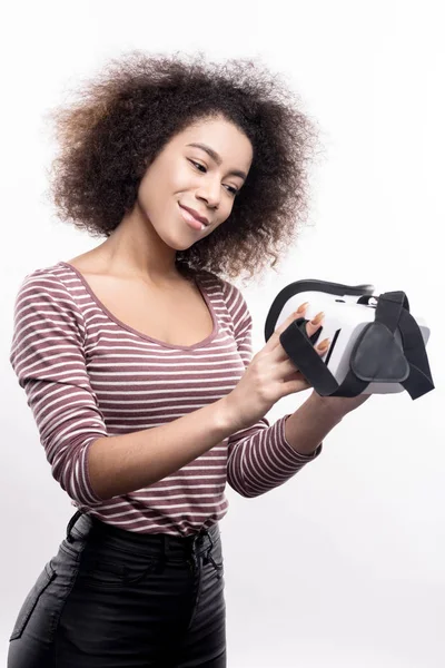 Mulher agradável olhando para seu novo fone de ouvido VR com amor — Fotografia de Stock