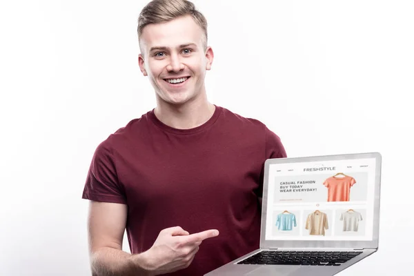 Uomo affascinante che mostra il sito web del negozio di abbigliamento online — Foto Stock