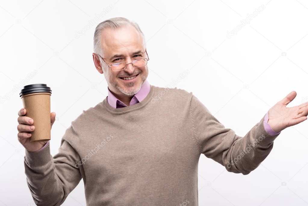 Pleasant senior man posing with a cup of coffee