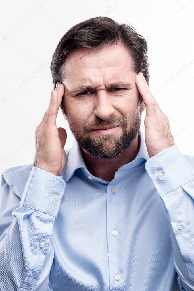 Bearded middle-aged man suffering from migraine