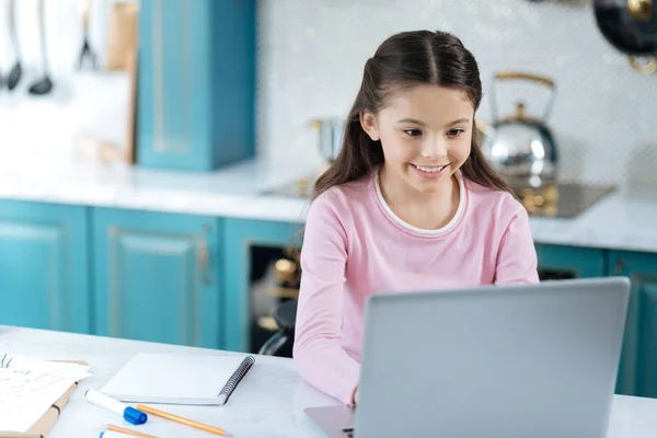 Innehåll ung flicka arbetar på hennes laptop — Stockfoto