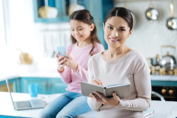 Glada kvinna håller en anteckningsbok och leende — Stockfoto