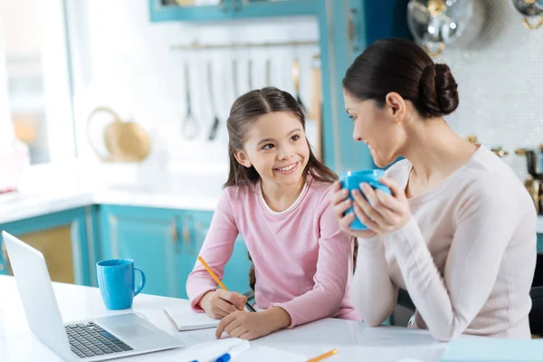 Alegre madre e hija haciendo la tarea juntas —  Fotos de Stock