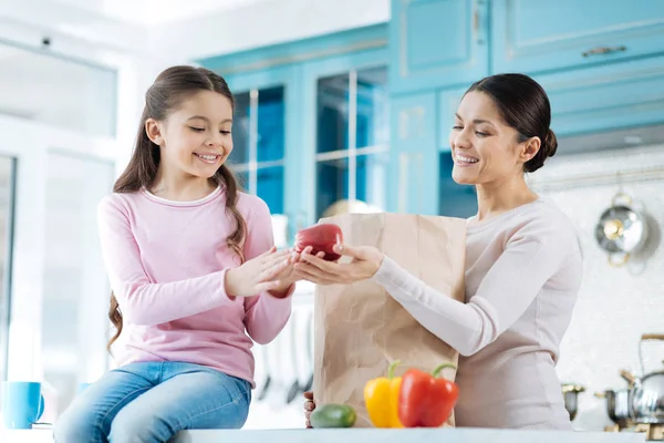 Inspired woman giving an apple to her girl