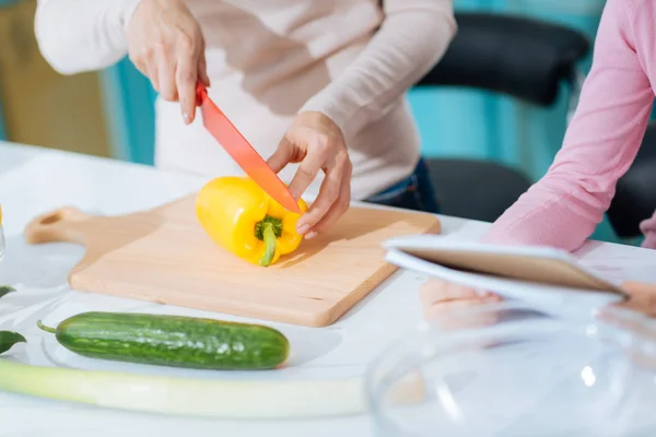 Loving mother chopping a pepper — Stock Photo, Image
