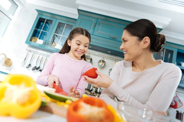 Joyful girl smiling and chopping vegetables — Stock Photo, Image