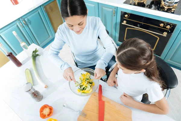 Восхитительная мать и девочка заканчивают делать салат — стоковое фото