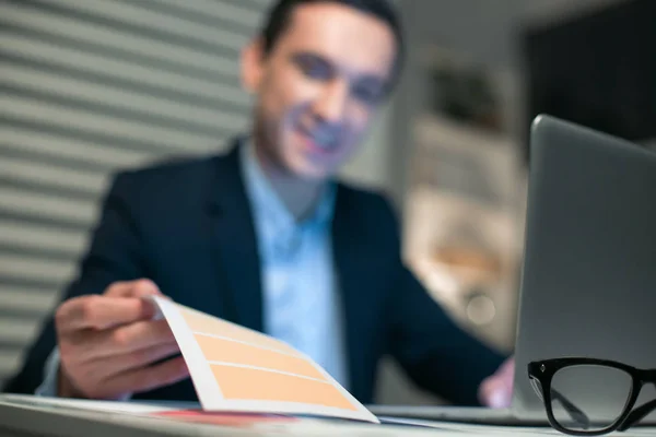 Joven hombre de negocios agradable tomando papel de apuntador — Foto de Stock