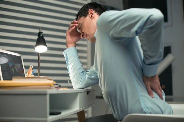 Расстроенный работник мужчина испытывает боль в спине — стоковое фото