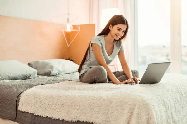 Ragazza adolescente allegra che chatta sul computer portatile — Foto Stock