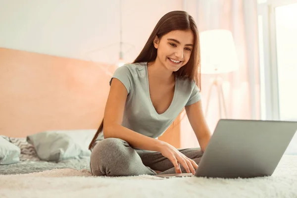 Menina adolescente bonita digitando no laptop — Fotografia de Stock