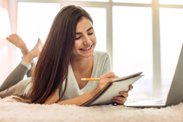 Pretty female student doing her home assignment — Stock Photo, Image