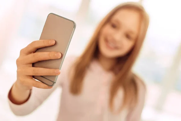 Blondes Mädchen hält Handy und macht Selfie — Stockfoto