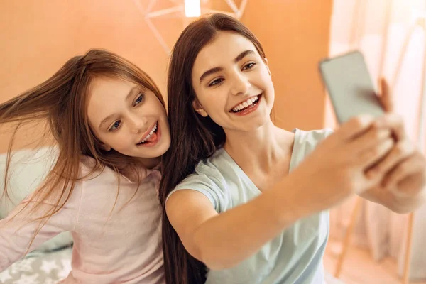 Ganska tonårsflickor har roligt medan du tar selfies — Stockfoto