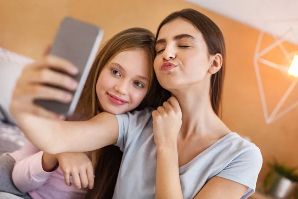 Adorables hermanas tomando selfies en el dormitorio — Foto de Stock