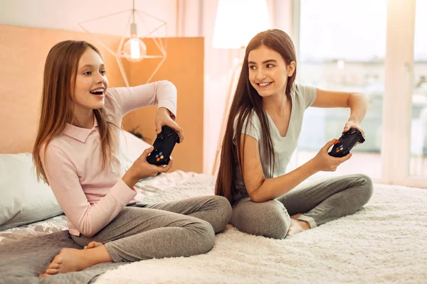 Dos hermanas adolescentes jugando con entusiasmo a videojuegos — Foto de Stock