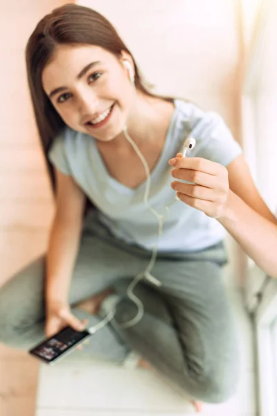 Vista superior de la chica adolescente entregando un auricular —  Fotos de Stock