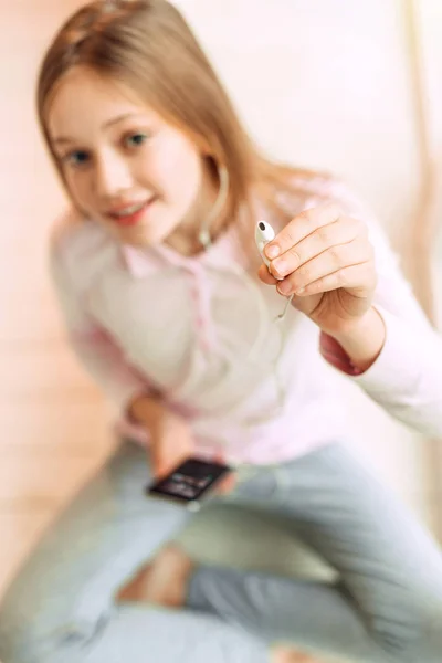 Χαριτωμένο εφηβικό κορίτσι δίνοντας ένα ακουστικό — Φωτογραφία Αρχείου
