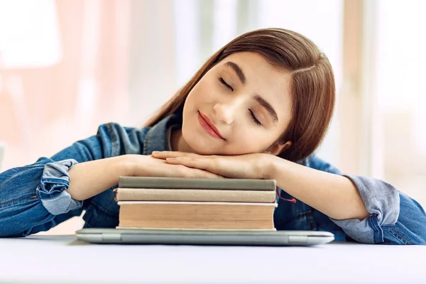 Menina adolescente bonito dormindo em uma pilha de livros — Fotografia de Stock