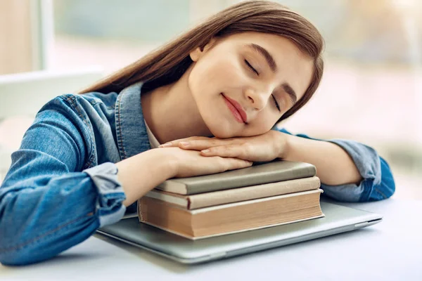 Menina agradável tirar uma soneca em pilha de livros — Fotografia de Stock