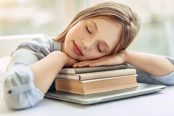 Маленькая девочка-подросток дремлет на книгах — стоковое фото