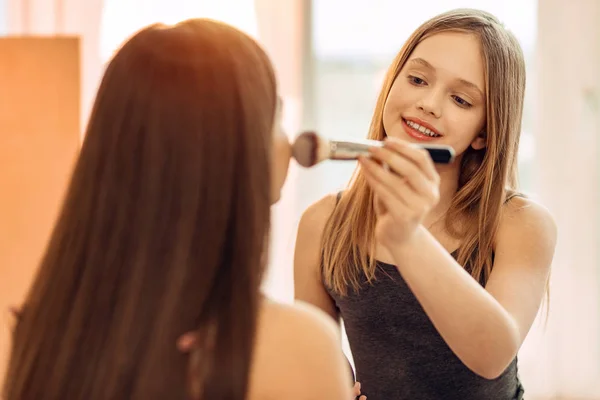 Pleasant teenage girl practicing in applying makeup — Stock Photo, Image
