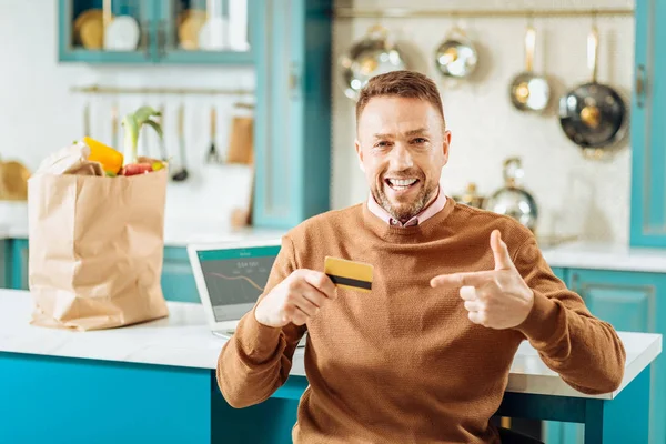 Feliz buen hombre apuntando a la tarjeta de crédito — Foto de Stock