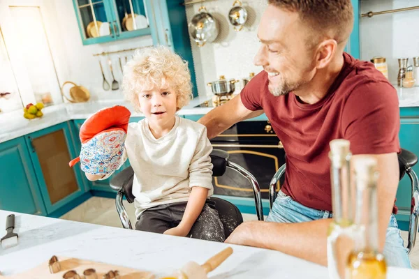 Positivo niño feliz jugando con un guante de horno — Foto de Stock