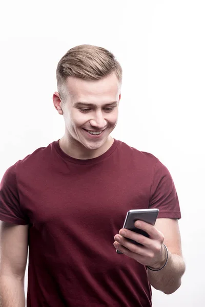 Fair-haired young man reading messages on phone — Stock Photo, Image