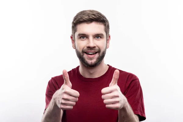 Optymistyczny człowiek pokazuje kciuk w i uśmiechając się — Zdjęcie stockowe