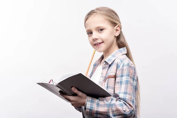 Trevlig liten flicka hålla anteckningsboken och poserar — Stockfoto