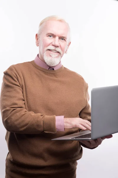 Pria senior berpose saat menggunakan laptop — Stok Foto