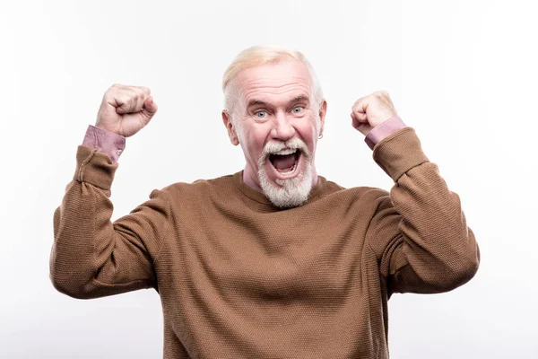 Щасливий старший чоловік піднімає руки в урочистому жесті — стокове фото