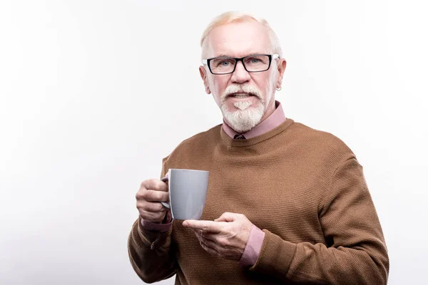 Piacevole uomo anziano in occhiali con in mano una tazza di caffè — Foto Stock