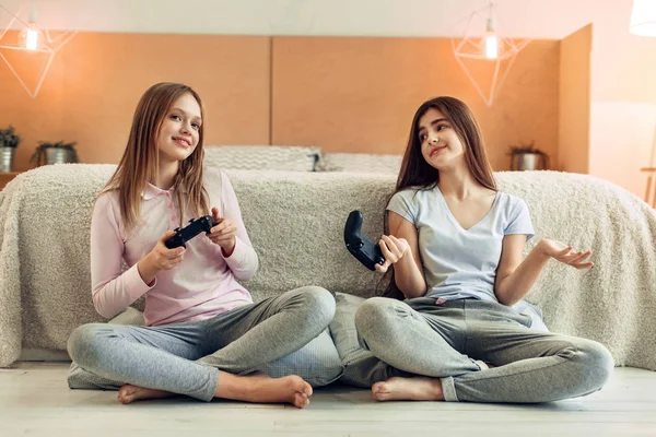 Pretty girl being disappointed by loss in game against sister — Stock Image Pretty girl being disappointed by loss in game against sister Royalty Free Stock Photos